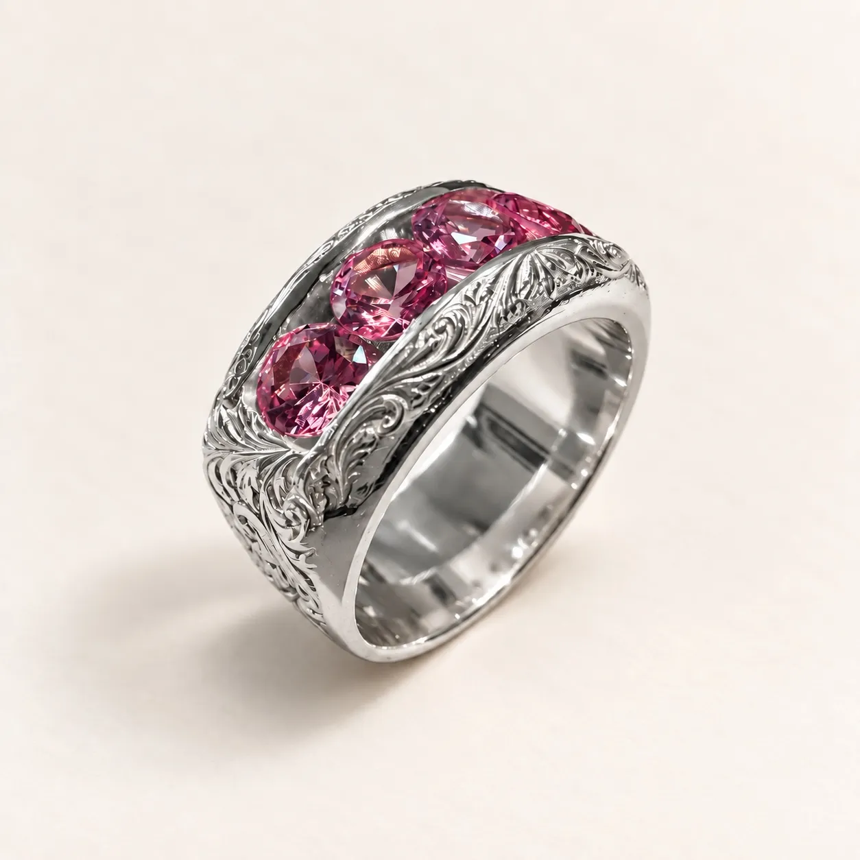 Three-quarter view of Redemption, a wide silver ring with five pink cubic zirconia stones and flowing scrollwork.