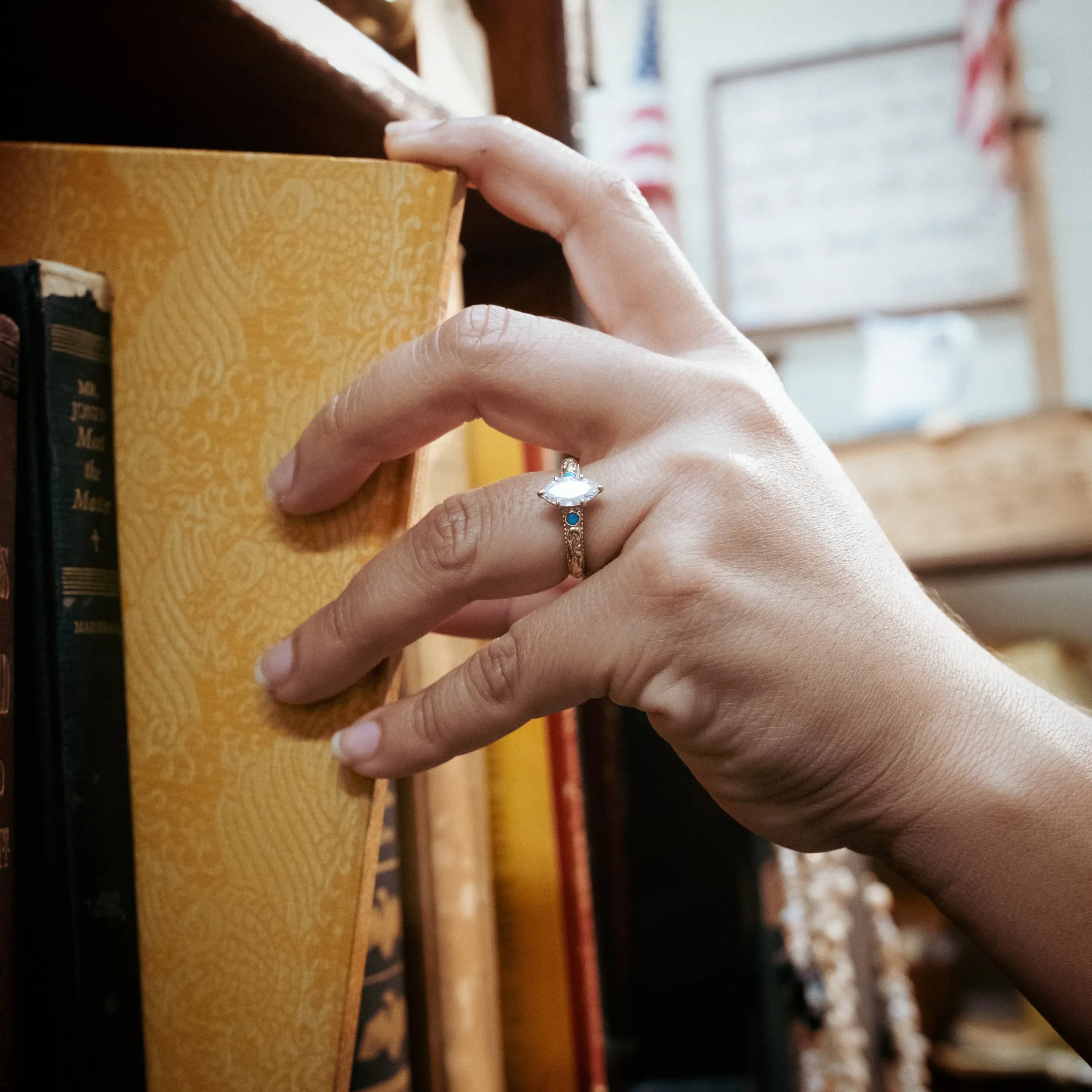 The Cindy worn on the hand, reaching for a book on a shelf in the shop.